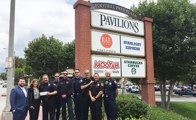 Members from the Monrovia Police Department and Firefighters Association gather in front of Foothill Park Plaza to accept donation from Westar Associates. 